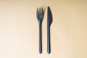 plastic spoon and knife on a yellow background, top view, concept, space for text, mock-up