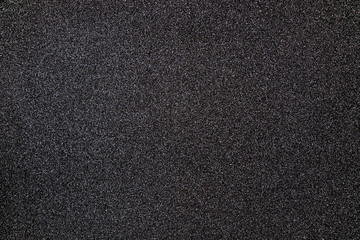 Black giltter texture abstract background. Shiny wrapper paper.