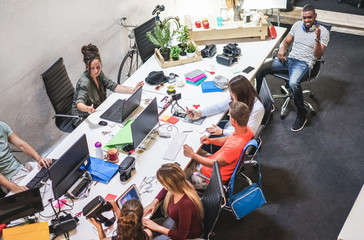 Young co-workers team talking during startup - Happy people planning a new project in creative...
