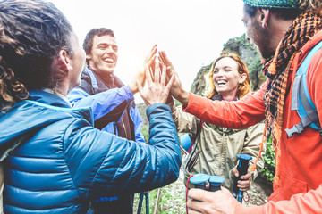 Group of happy trekkers stacking hands outdoor - Young hiker friends supporting each others -...