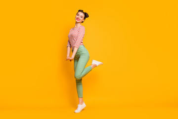 Fototapeta na wymiar Full length profile photo of pretty lady enjoy warm spring day traveling abroad wear casual red white shirt green pants footwear isolated bright yellow color background