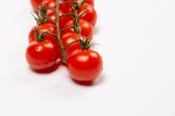 Cherry tomatoes covered drops on a white background