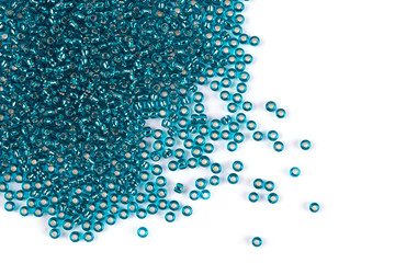 Green beads scattered beads on a white background, top view, costume jewelry