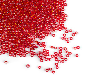 Red beads scattered beads on a white background, top view, costume jewelry