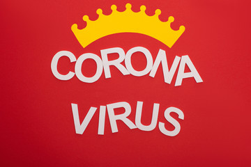 Top view of coronavirus lettering with crown isolated on red
