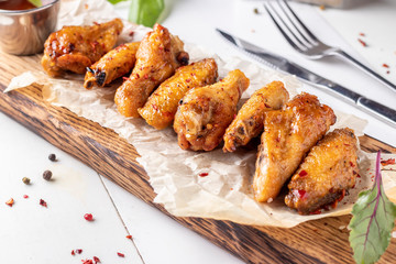Grilled chicken wings are located on a wooden board