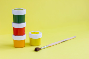 Colorful vibrant cans of gouache paint and brushes. Colorful paint cans set. Painting background. A...