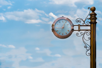 Street clock on sky background. Classic style streeet clock.