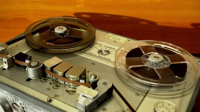 Close up of a vintage professional analog reel-to-reel audio magnetic tape recorder.
