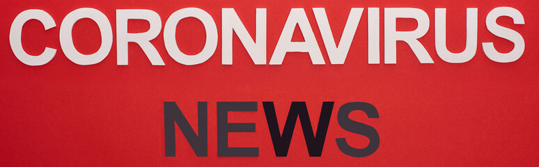 Fototapeta na wymiar Top view of coronavirus news lettering isolated on red, panoramic shot