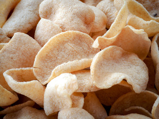 Thai food, many white plate shrimp prawn crackers, newly fried Piles assembled in a sieve waiting to be served.
