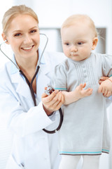 Doctor and patient in hospital. Little girl is being examined by doctor with stethoscope. Medicine concept