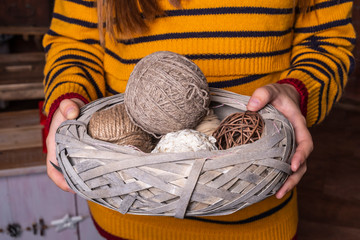 Woman is holding yarn balls in basket. Concept of a woman's hobby. Knitting hobby concept.