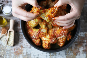 The man is eating chicken wings. Fried chicken wings.