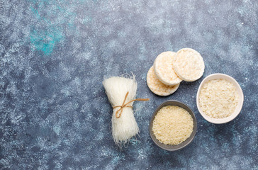 Rice flakes,rice noodles,rice bread and rice on dark background,top view