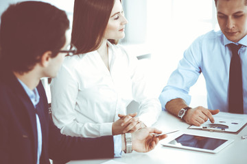 Obraz premium Group of business people discussing questions at meeting in modern office. Managers at negotiation or brainstorm. Teamwork, partnership and business concept