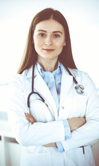 Doctor woman standing straight with arms crossed, portrait. Perfect medical service in clinic. Medicine and healthcare concepts