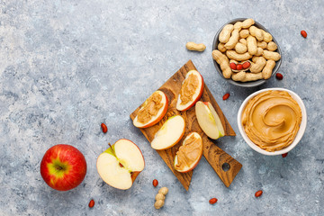 Homemade peanut butter with peanuts on grey concrete background,top view