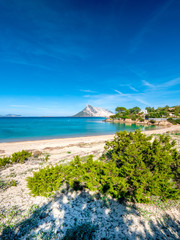 Clear water of sardinian beach called Cala Girgolu, with view on Tavolara island