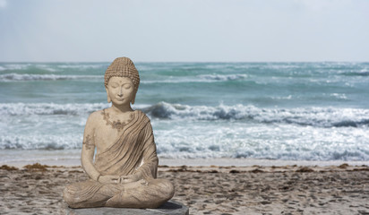 Buddha statue for meditation and relaxation on the beach facing the Caribbean ocean in Tulum Mexico
