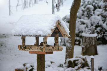 Bird feeder in winter covered with snow. Home made. Helping birds in winter
