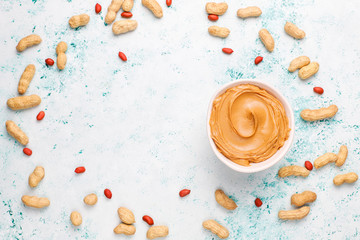 Homemade peanut butter with peanuts on grey concrete background,top view