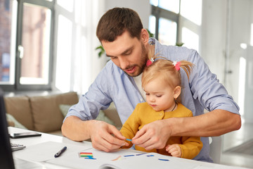 multi-tasking, freelance and fatherhood concept - working father with baby daughter at home office