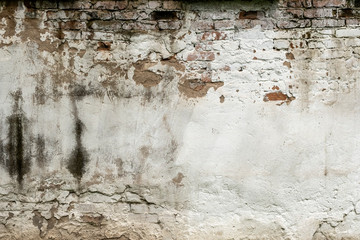 Old damaged brick wall with plaster background texture.