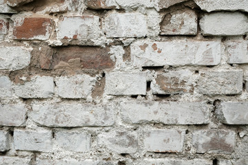 Old damaged brick wall with plaster background texture.