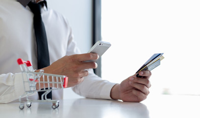 Businessman use mobile phones to register for security Online with a credit card to buy products online through application,Online shopping or Internet technology concept.