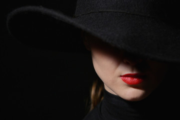A Woman With Red Lips In A Black Hat