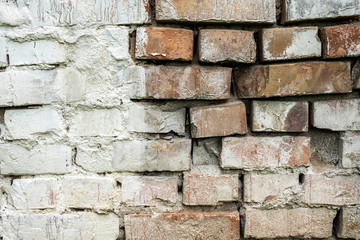 Old damaged brick wall with plaster background texture.