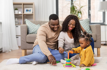 family, parenthood and people concept - happy african american mother, father and baby daughter...