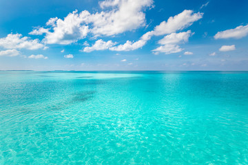 Tropical sea backdrop. Beautiful white clouds on blue sky over calm sea with sunlight reflection. Tranquil sea harmony of calm water surface. Sunny sky and calm blue ocean.