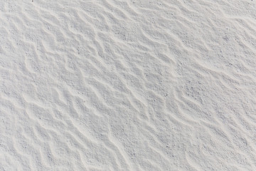 Fototapeta na wymiar White sand texture, wind formed sand waves. Exotic nature pattern