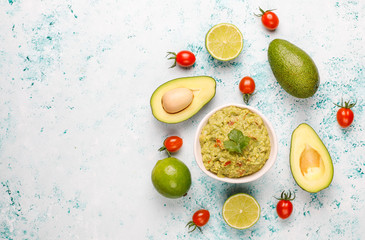 Fresh homemade hot guacamole sauce with ingredients on light background,top view