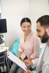 Bearded young doctor explaining investigation results to the patient