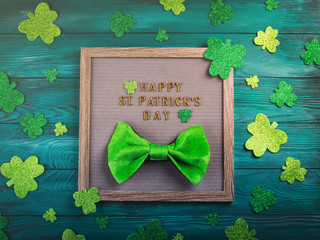 St Patrick Day greetings on letter board on dark green wooden rustic background with shamrocks and...