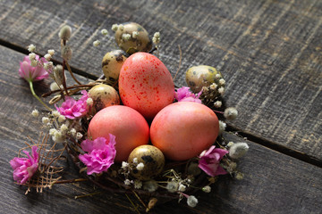 Fototapeta na wymiar Easter eggs on wooden background. Pink handmade easter eggs in a basket. Copy space.