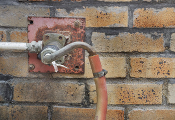 Fire hydrant hose installed at brick wall