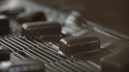 Production line for the production of chocolates. Candy covered with chocolate. Sweets move along the conveyor. Panorama. Chocolates on the conveyor.
