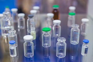 Medical empty glass bottles in showcase at pharmaceutical exhibition, pharmacy laboratory. Pharma industry, science, medicine, experiment, chemistry, research and healthcare concept.