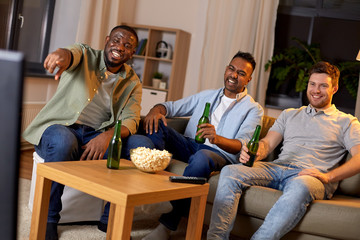 friendship, leisure and people concept - happy male friends with beer and popcorn watching tv at...