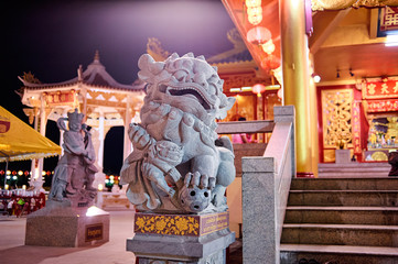 Statue of stone Chinese dragon lion on temple in Phuket, Thailand.