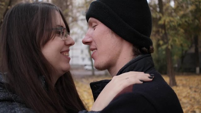 man and woman kiss in the park