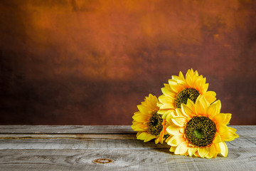 Glass jar with sunflowers on a wooden table