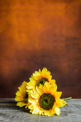 Glass jar with sunflowers on a wooden table