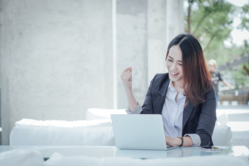 Asian business woman with laptop happy and smile concept success work