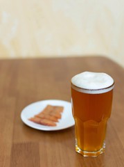 Beer in a glass on the table and a plate with fish