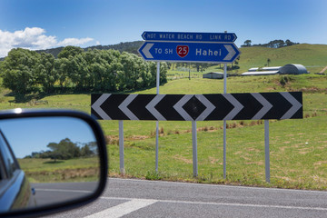 Coromandel New Zealand road sign Hahei Car rear view mirror. Highway 25.